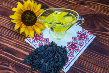 wooden background with sunflower oil, seeds and a sunflower