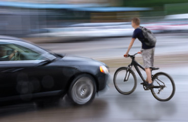 Dangerous city traffic situation with cyclist and car in the city in motion blu