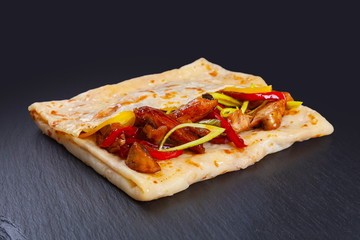 Pancake with chicken on black background
