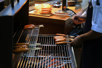 Grilling sausages on barbecue grill. BBQ in the garden. Bavarian sausages.