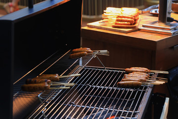 Grilling sausages on barbecue grill. BBQ in the garden. Bavarian sausages.
