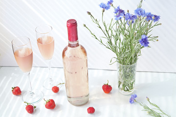a bottle of rose wine and two glasses