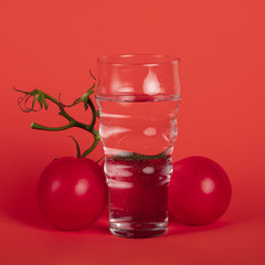 Glass of water surrounded by tomatoes