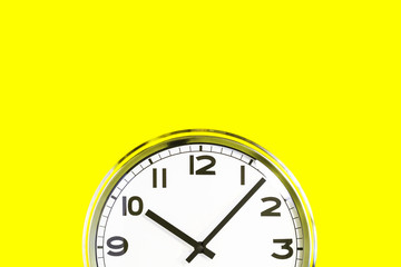 Fototapeta na wymiar Part of analogue plain wall clock on trendy yellow background. Ten o'clock. Close up with copy space, time management or school concept and opening hours closing time