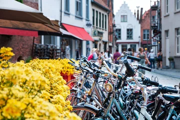 Gordijnen Bicycles parked near yellow flowers © frimufilms