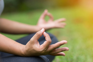 Woman do yoga outdoor, Yoga in the park, Close up hands, Concept of healthy lifestyle and relaxation.