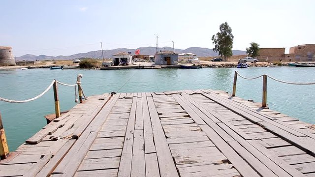 riding on a handmade raft across lake Butrint in Albania, on the road to the tourist town Ksamil
