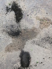 beautiful industrial background and texture black shapeless spots on a gray concrete floor with sand
