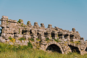 Fototapeta na wymiar Old aqueduct in Side. Ruins of the ancient city of Turkey. Antalya coast.Antalya Province. Pamphylia. Ancient building. Historical place