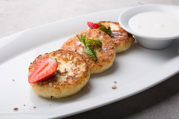 fried pancakes served with strawberry and sour cream