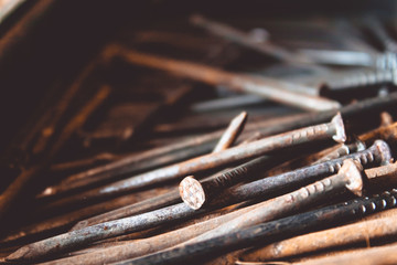 Old rusty nails lie in a drawer. Tools for construction work.