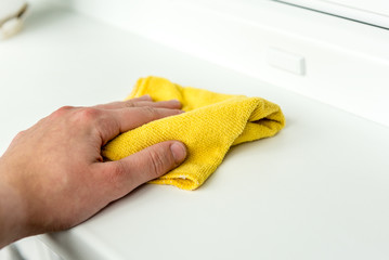 Hand dusting a window rag to reduce allergens in the home.