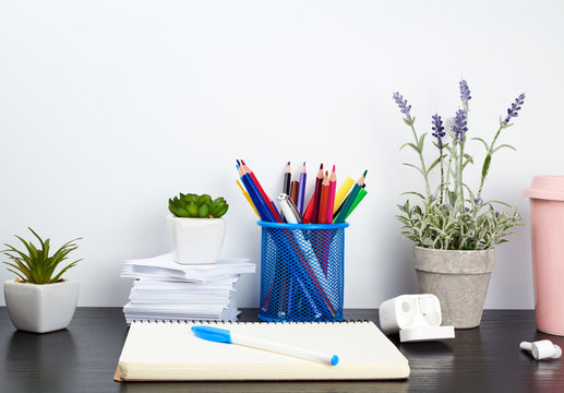 spiral notebooks, ceramic cup with coffee and colorful pencils