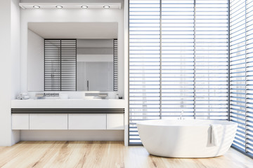 White bathroom with tub, sink and blinds