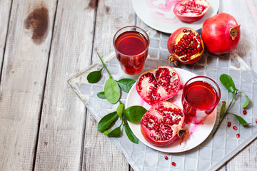 Pomegranate juice with fresh pomegranate fruits on wooden table