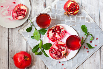 Pomegranate juice with fresh pomegranate fruits on wooden table