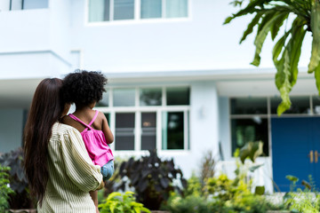 Rear View Of Happy Diverse Family or Parents Looking At House. Single mom standing in front of her...