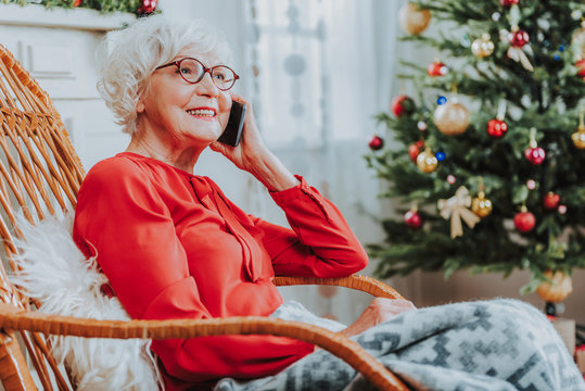 Smiling mature woman is talking on smartphone