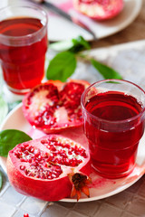 Pomegranate juice with fresh pomegranate fruits on wooden table