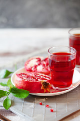 Pomegranate juice with fresh pomegranate fruits on wooden table