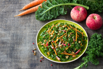 Healthy cabbage kale salad with carrots, apple and walnut on wooden background. delicious homemade diet food - obrazy, fototapety, plakaty