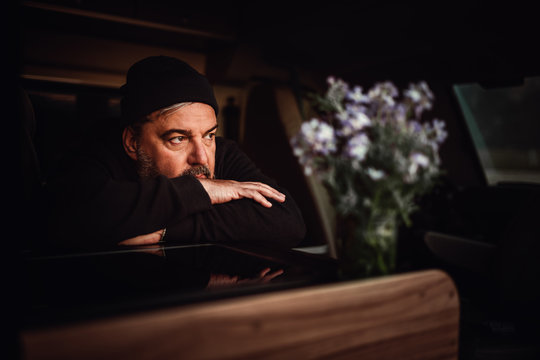 Mann mit M&uuml;tze und Vollbart sitzt im Reisewagen