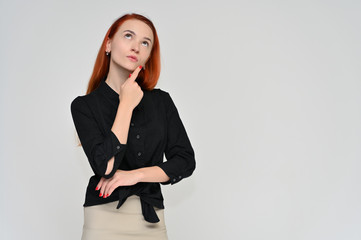 Portrait of a pretty red-haired girl, a happy young woman manager in a business suit on a white background in studio. Smiling, showing different emotions.