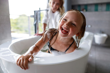 Happy cute girl is laughing in the bath