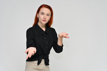 Portrait of a pretty red-haired girl, a happy young woman manager in a business suit on a white background in studio. Smiling, showing different emotions.
