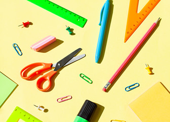 Colorful School stationery concept flat lay on the yellow paper background. Top view. 