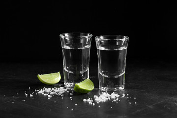 Vodka in shot glass on black background with a blank space for a text, Russian vodka with salt and...
