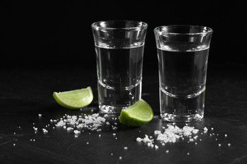 Vodka in shot glass on black background with a blank space for a text, Russian vodka with salt and lemon