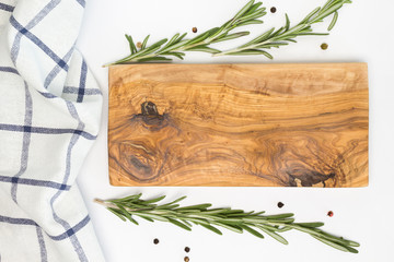 Wooden cutting board, towel, rosemary, pepper on white background. Cooking, recipe concept. Top view, flat lay, mock up, copy space