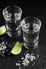Close up vodka in shot glass on black background, Russian vodka with salt and lemon