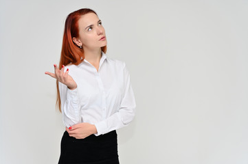 Portrait of a pretty red-haired girl, a happy young woman manager in a business suit on a white background in studio. Smiling, showing different emotions.