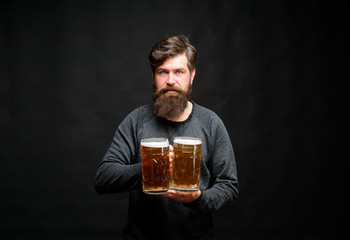 Oktoberfest. Beer pub. Smiling bearded hipster drinking craft beer from mug. Alcohol, harmful habits. Stylish handsome man drinking beer of glass on party. Brewing. Stylish guy at cafe pub. Beer time.