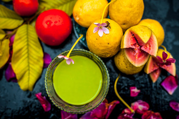Best cheap face mask for tanned skin on wooden surface un a glass bowl consisting of guava leaves paste well mixed with some tomato pulp. Shot with entire ingredients with fantastic colors.