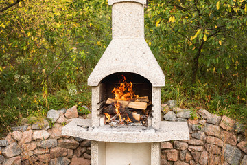 Stone garden oven for grill or barbeque is in a backyard