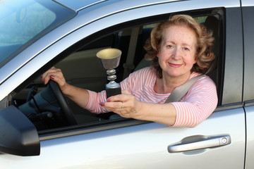 Senior female driver holding a trophy 