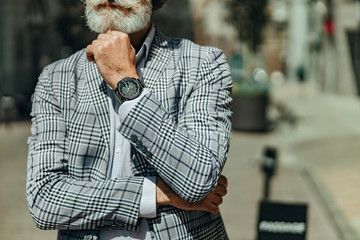 Bearded senior man propping up his head with hand