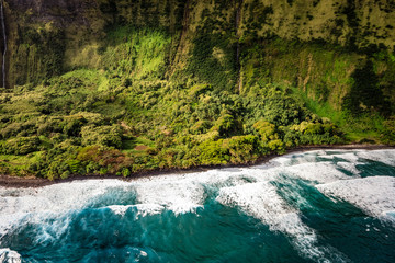 Rough ocean waves pound a lush green jungle coastline near Laupahoehoe Nui on the big island of Hawaii