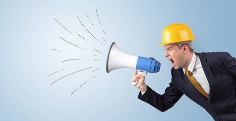 Fototapeta premium Young architect constructor yelling with megaphone and copyspace