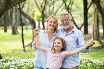 Happy male and female playing with children in park