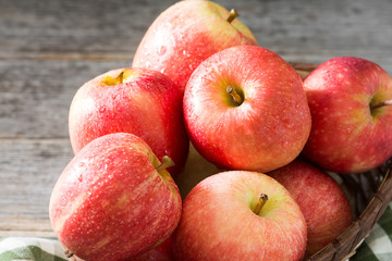 Apples in a basket on a gray wooden background. Autumn harvest