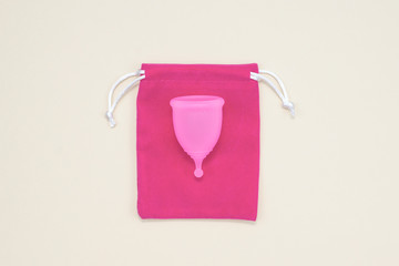 Menstrual cup with a pink cover, top view. Female body health and hygiene. Zero waste concept.