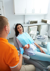 Pretty lady speaking with dentist in clinic