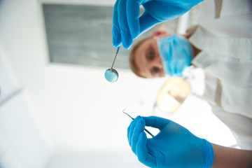 Fototapeta premium Professional adult stomatologist is holding dental tools