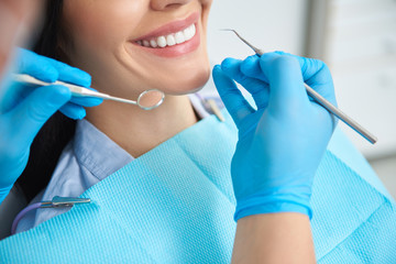 Dentist having view of female teeth in clinic