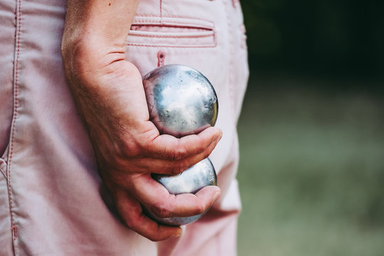 Boules de jeu de p&eacute;tanque dans les mains d'un homme