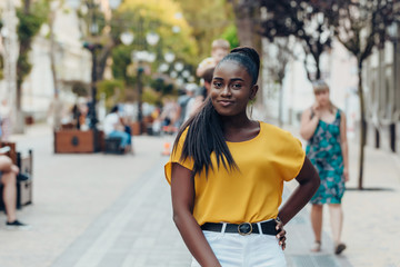 Young cool black skin girl walking in the street.